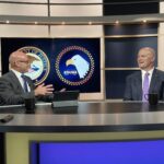 Chris Grollnek, active shooter expert,and Chuck Savickis seated in a DOJ studio discussion with a federal moderator, presenting prevention policy insights to 92 U.S. Attorneys and 10,700 Assistant U.S. Attorneys, with U.S. government emblems displayed in the background.