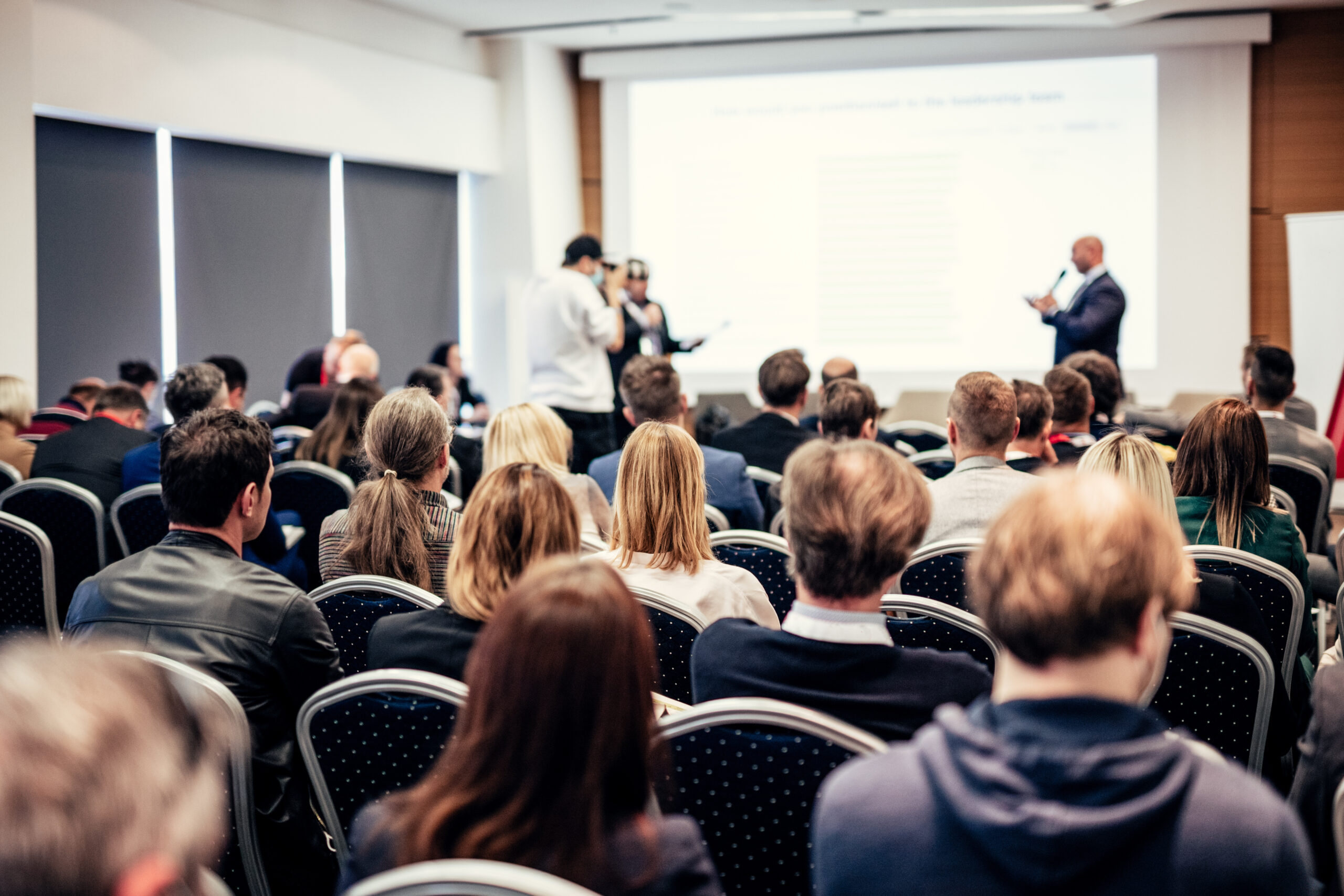 I have a question. Group of business people sitting in conference hall. Businessman raising his arm. Conference and Presentation. Business and Entrepreneurship