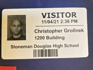 Visitor identification badge for Christopher Grollnek at Stoneman Douglas High School 1200 Building during post-Parkland shooting case involvement.