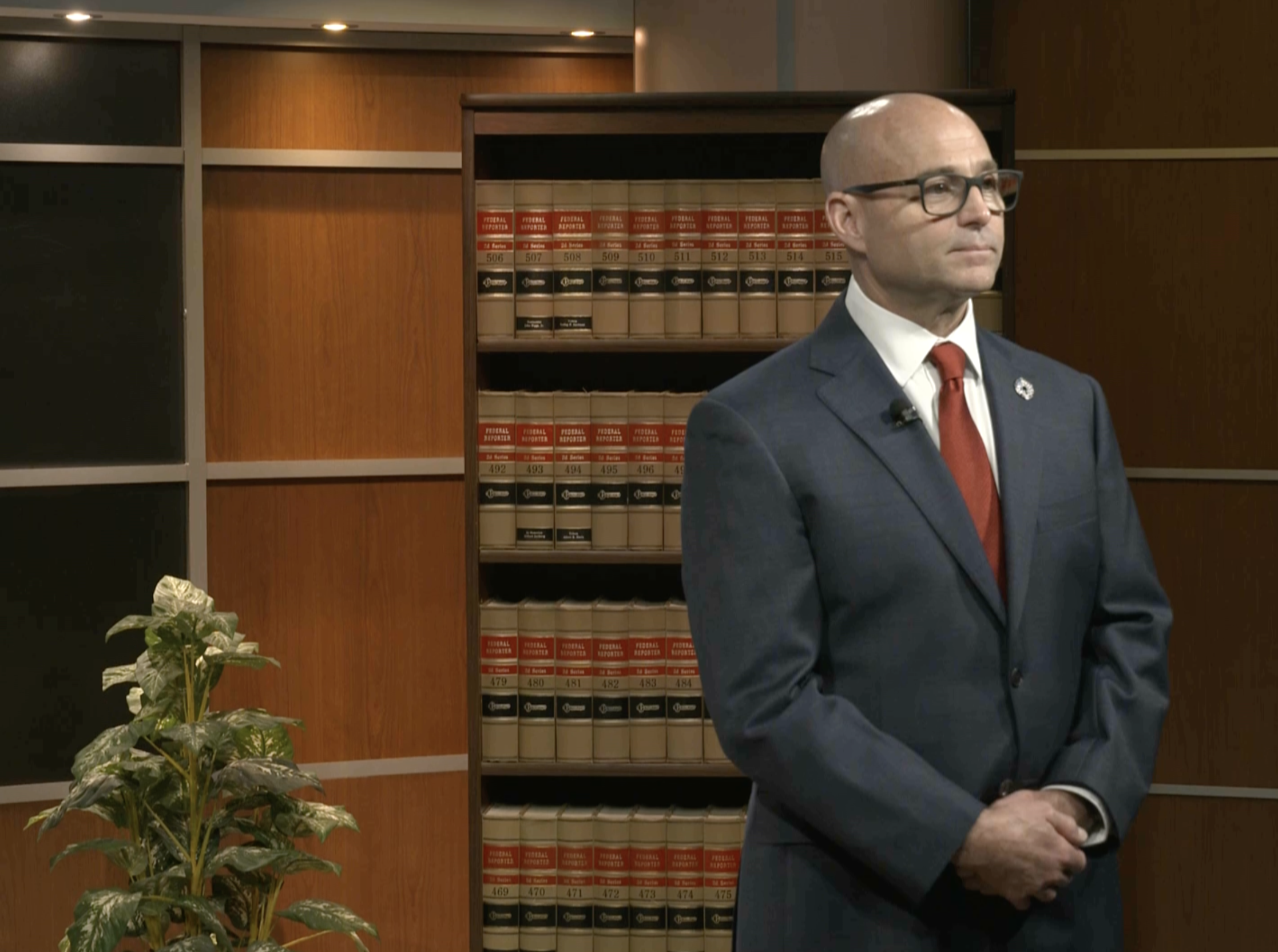 Chris Grollnek, Chairman and Founder of Active Shooter Prevention Project LLC, delivering an active shooter prevention executive briefing in a law firm setting with Federal Reporter volumes visible in the background