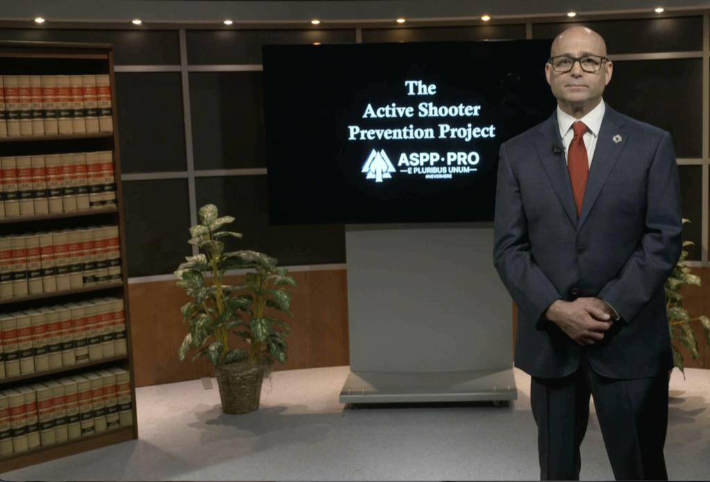 Chris Grollnek, Chairman and Founder of Active Shooter Prevention Project LLC, presenting the ASPP PRO Model™ active shooter prevention program to a law firm audience with legal volumes visible in the background